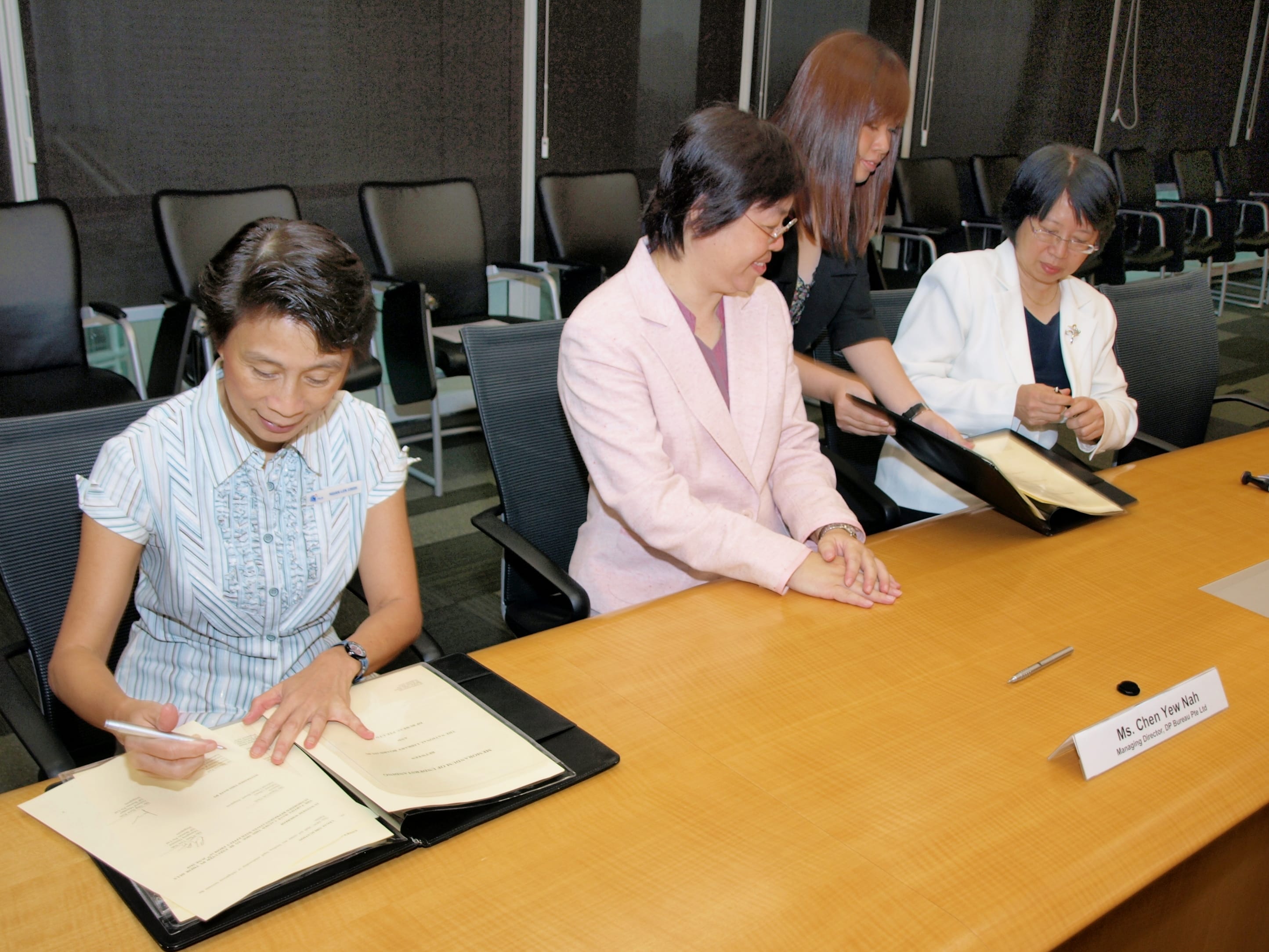 Signing of the Memorandum of Understanding for business advisory service by Ngian Lek Choh, Deputy Chief Executive, NLB (left) and Chen Yew Nah, Managing Director, DP Bureau (centre).